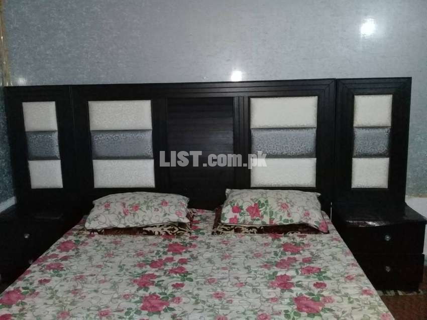Double bed with matress and two side tables.