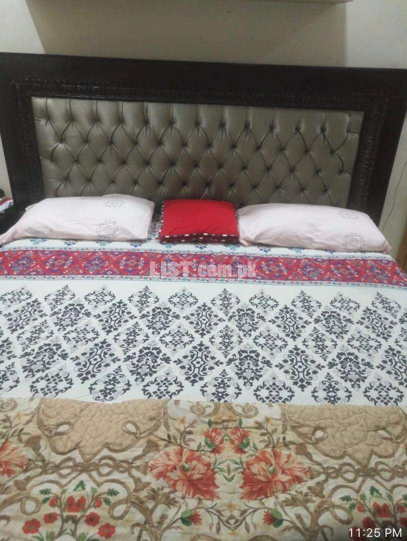 Bed along with dressing table and two side tables.